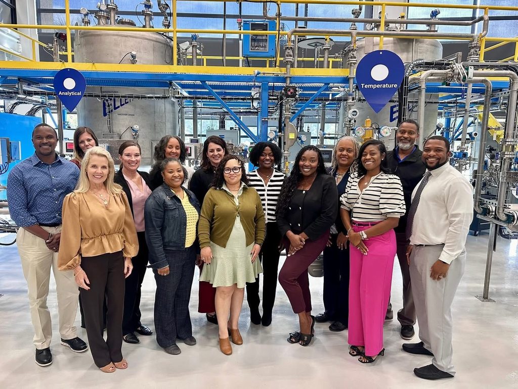 A group of educators standing in an industrial setting