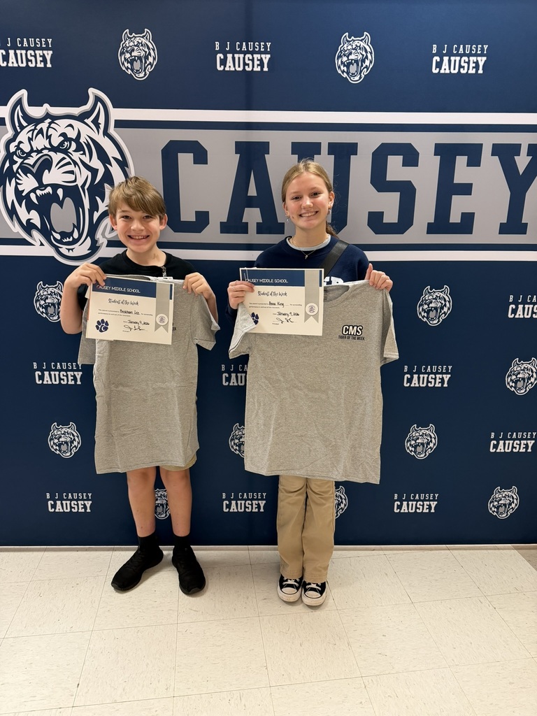 2 students holding up t-shirts and certificates