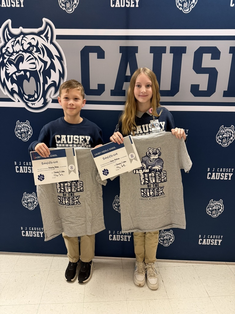 2 students holding up t-shirts and certificates