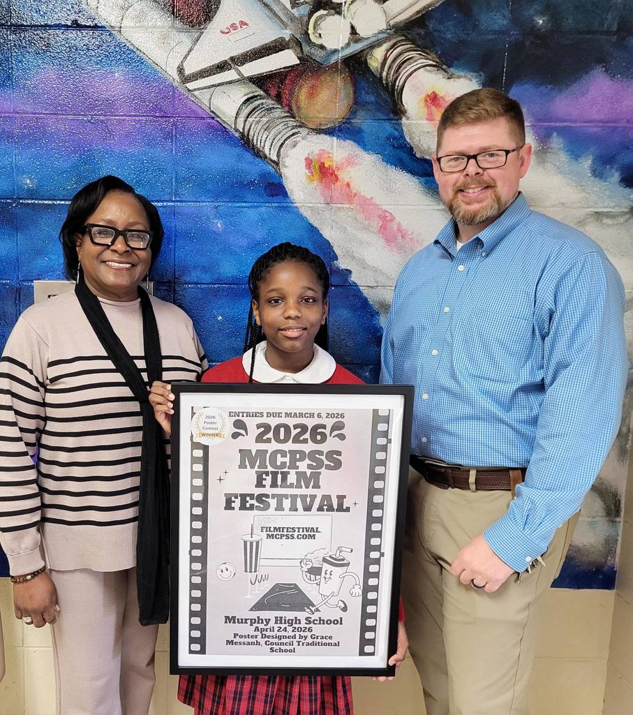 A girl holds a poster, standing with two adults