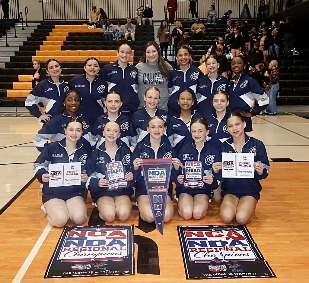 A group photo of a dance team in a gymnasium