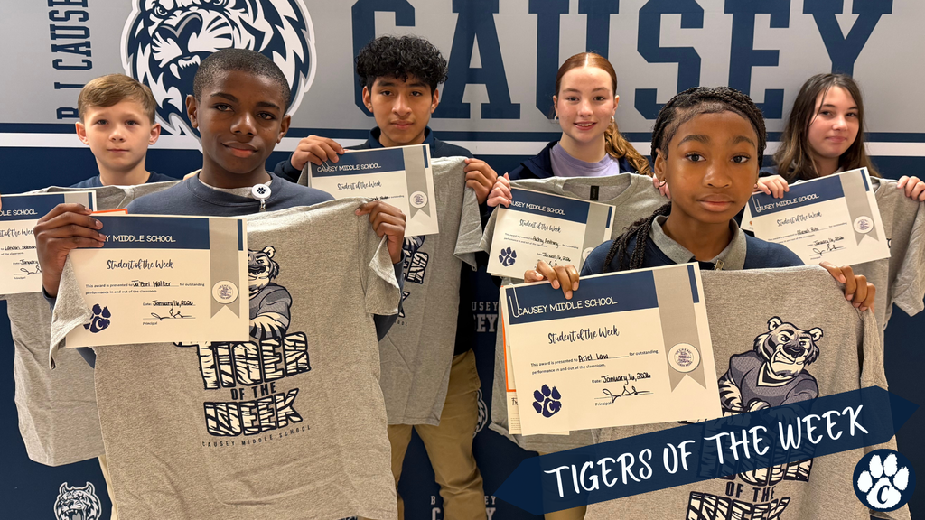 Students holding t-shirts and certificates, Tigers of the week