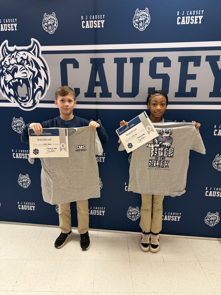 2 students holding up t-shirts and certificates
