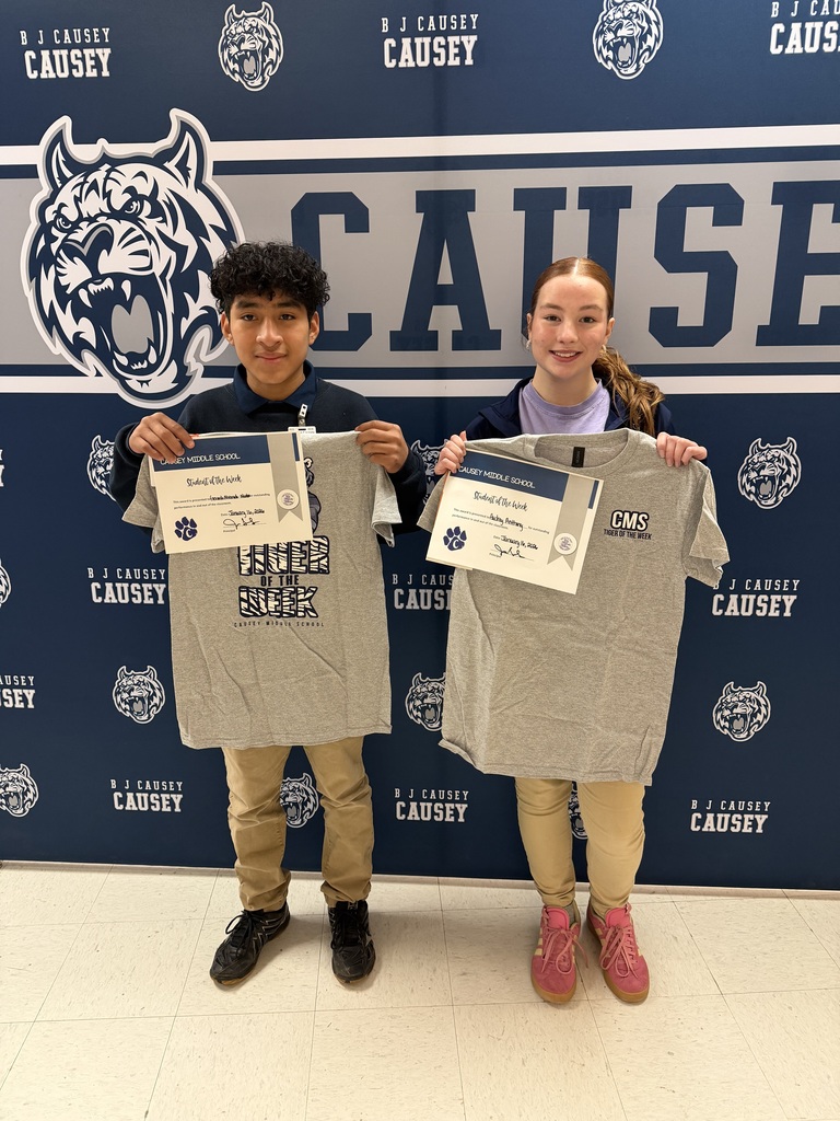 2 students holding up t-shirts and certificates