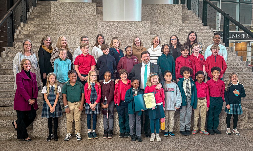 A large group of elementary students and teachers with Mobile Mayor Spiro Cheriogotis