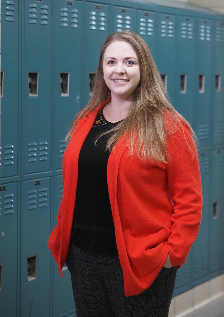 A teacher standing in front of lockers
