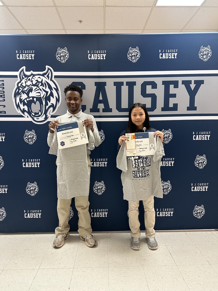 2 students holding up t-shirts and certificates