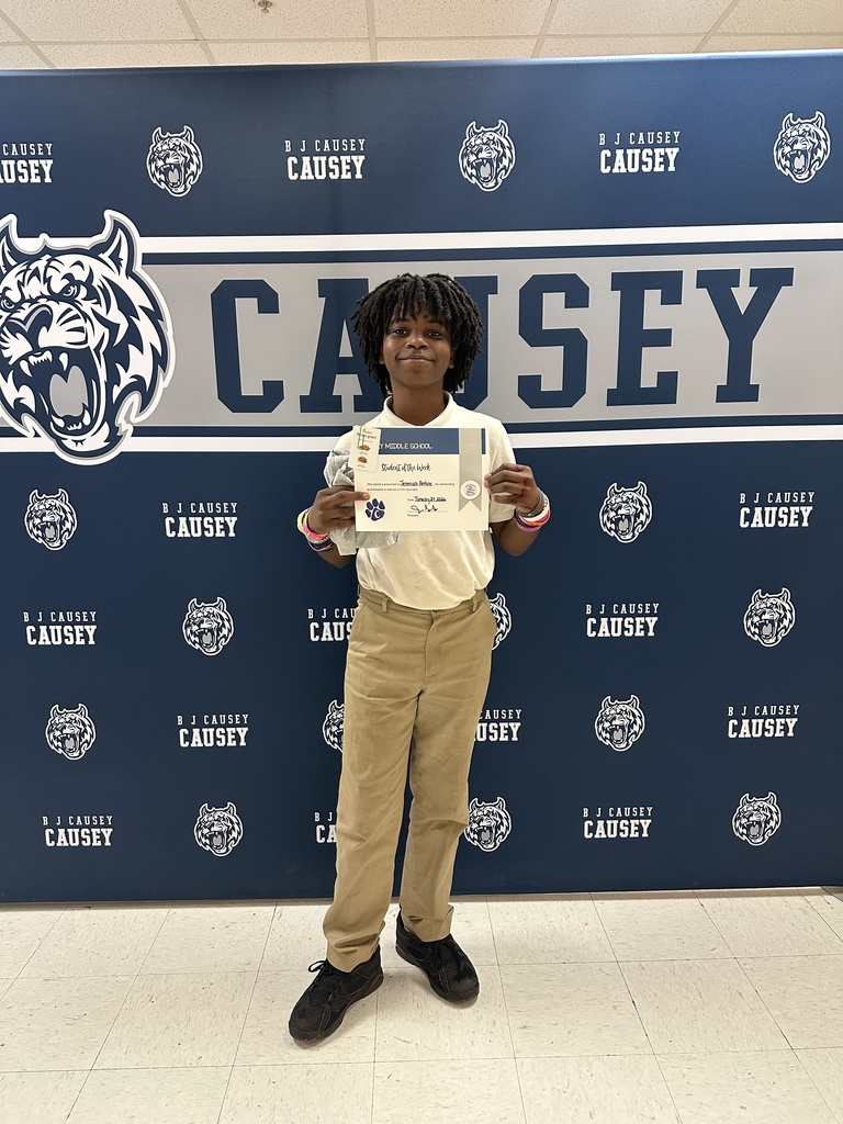 Student holding t-shirt and certificate