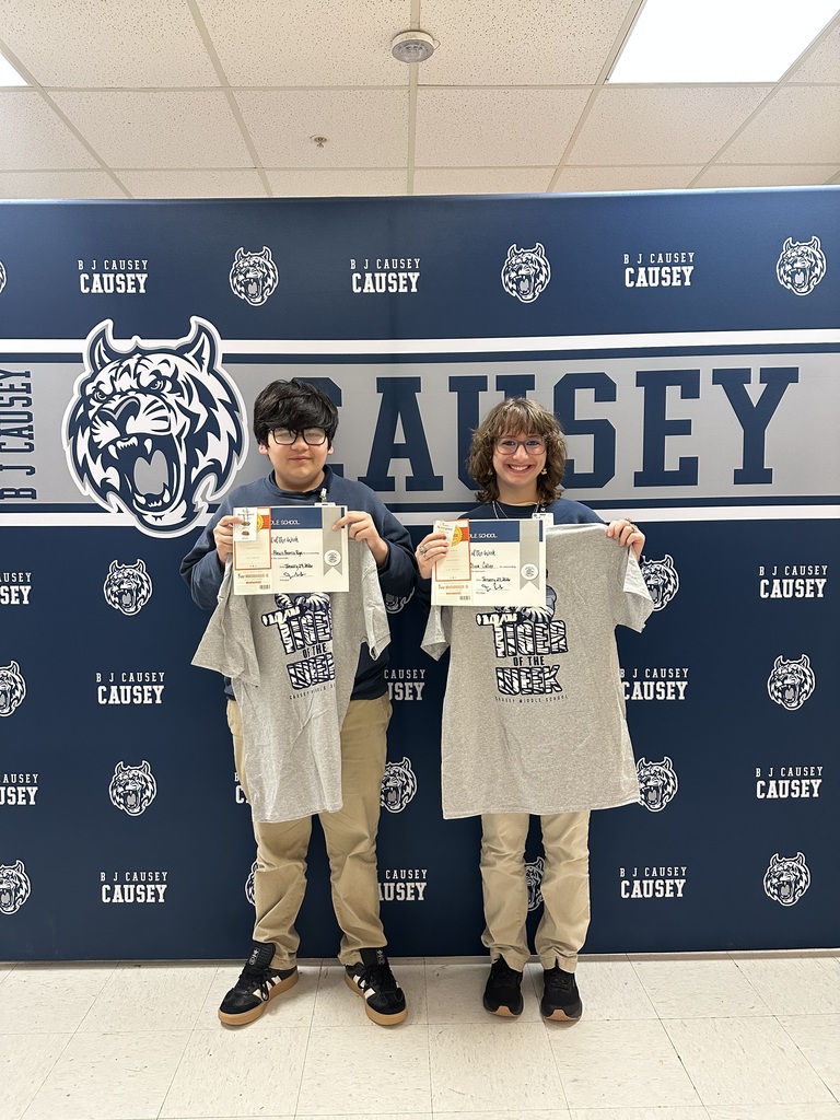 2 students holding up t-shirts and certificates