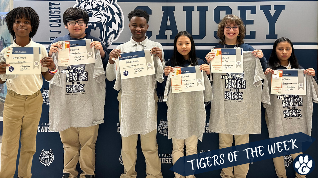 Students holding t-shirts and certificates