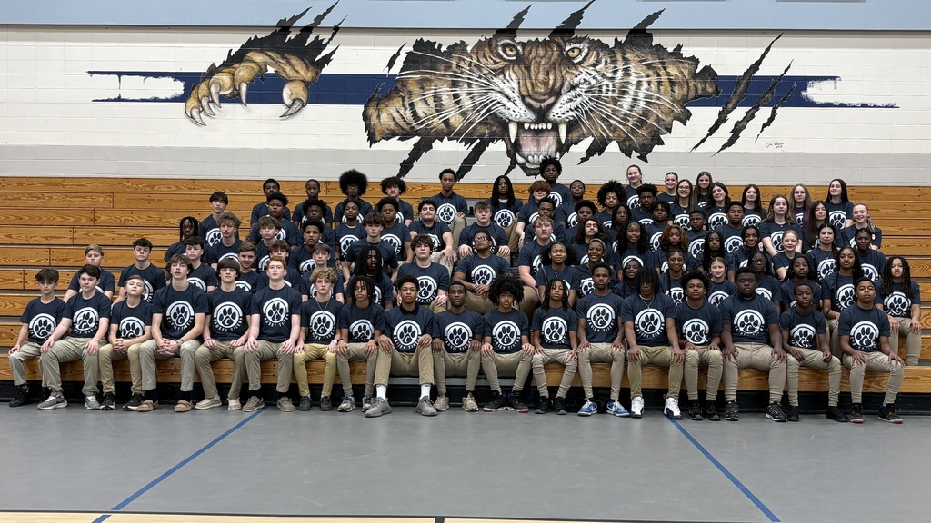 Group photo of students in bleachers wearing matching shirts