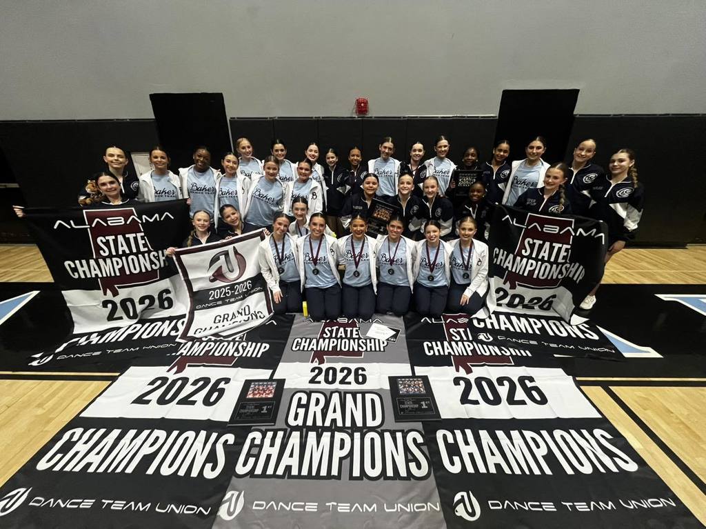 A group of dance team members with several banners reading "2026 Champions"