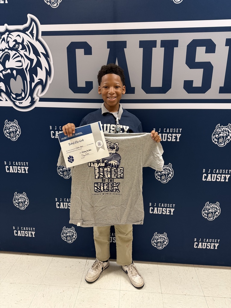 Student holding t-shirt and certificate