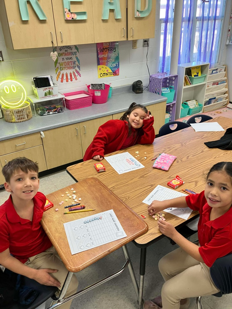 a group of students using candy hearts to create a graph