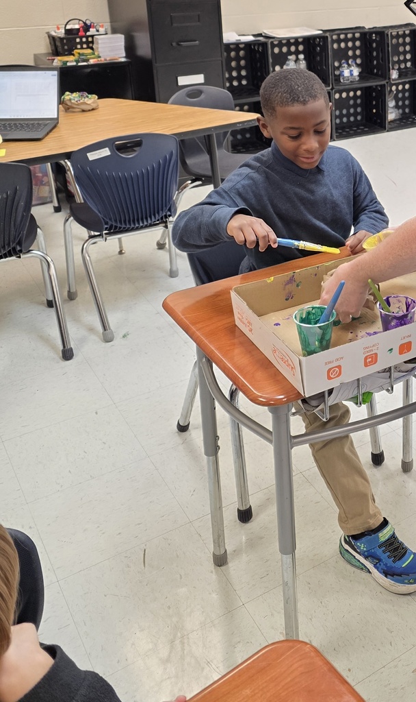 Student creating an art projects with paint 