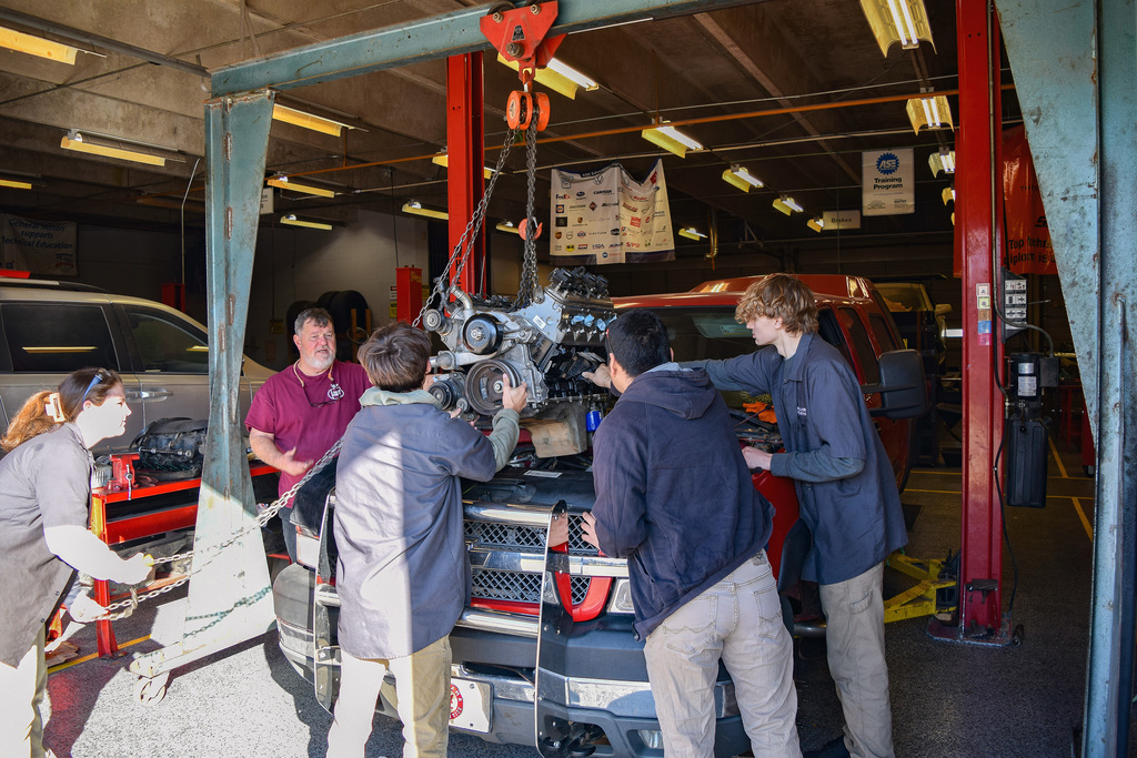 automotive students learning how to install a motor