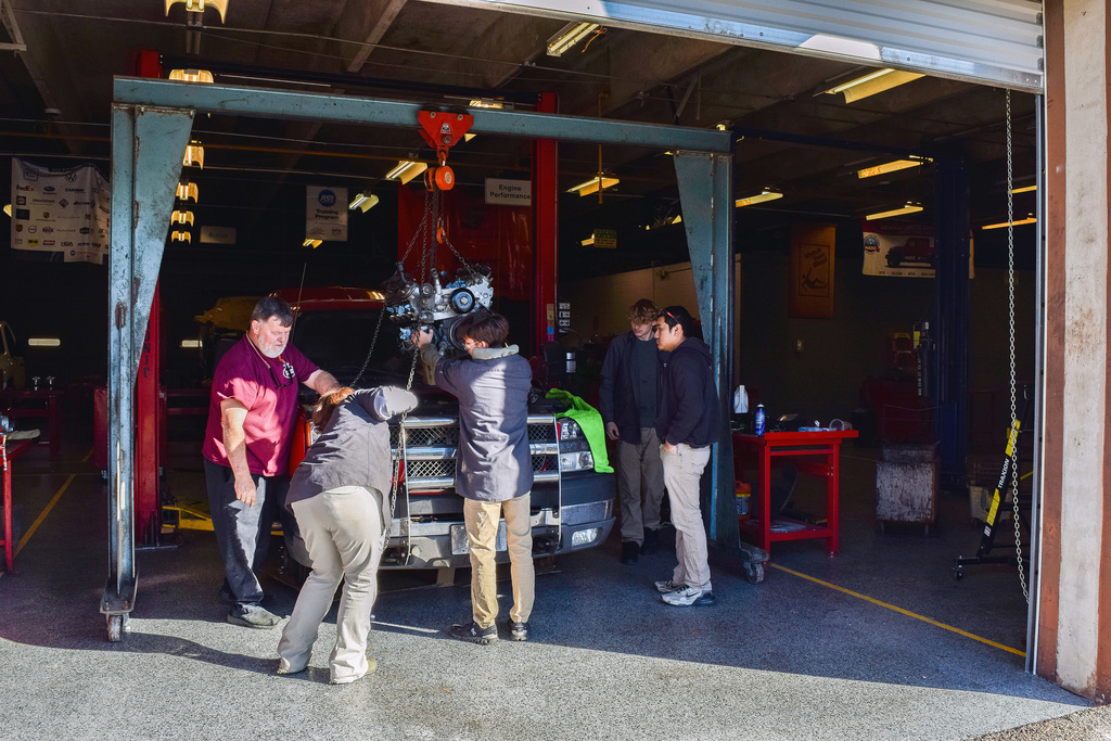 automotive students learning how to install a motor