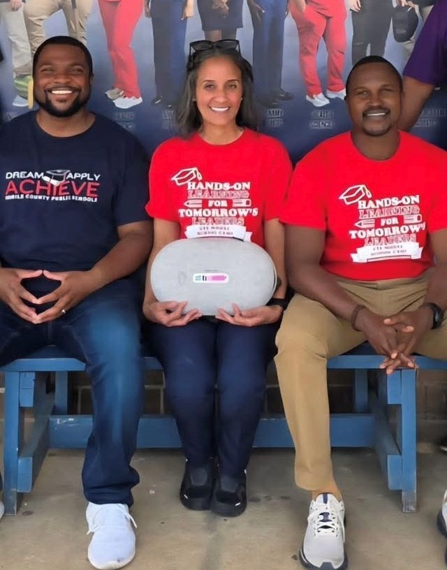 Two men and a woman seated on a bench