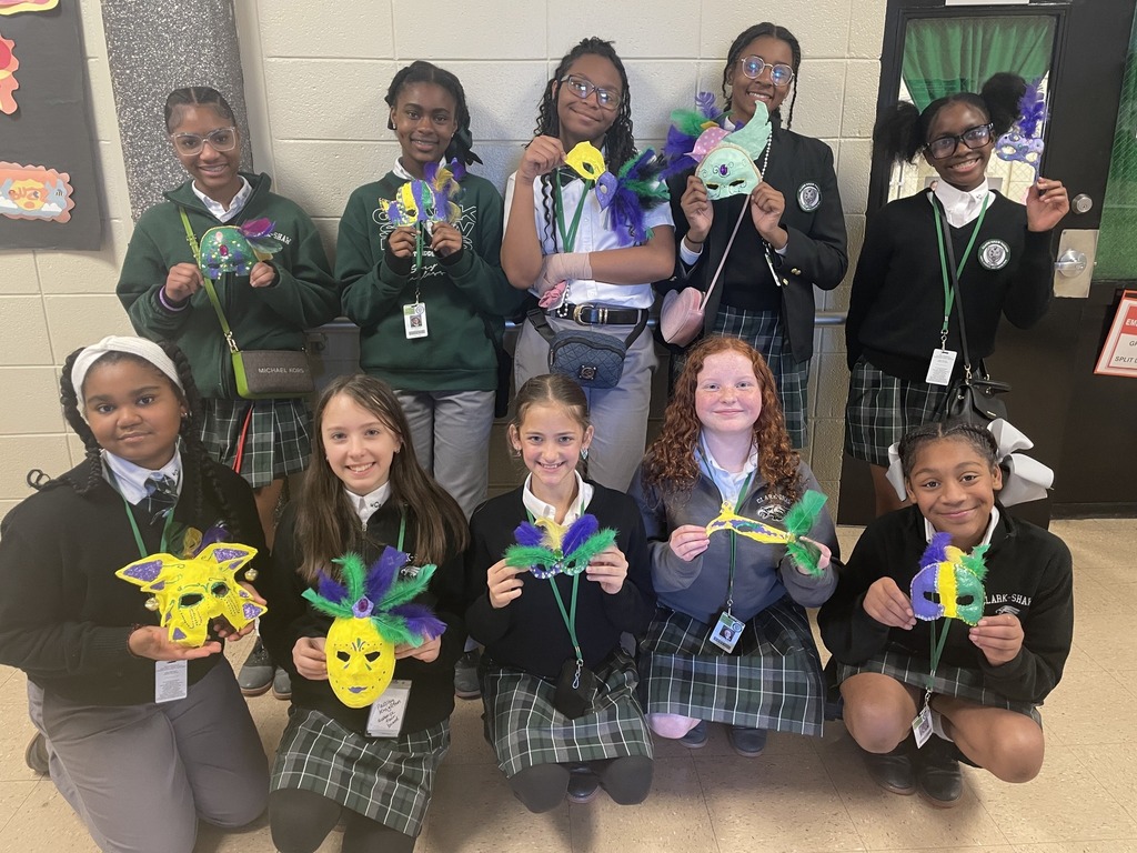 A group of students holding handmade Mardi Gras masks