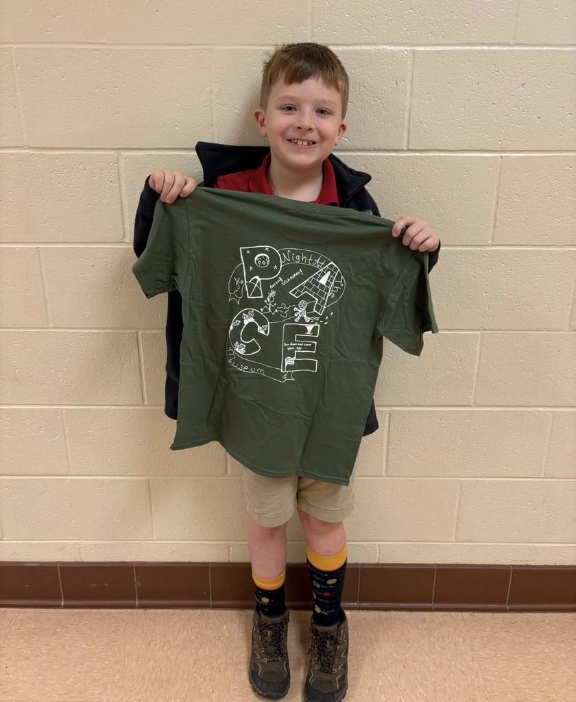 A boy holding a green T-shirt that reads "PACE"