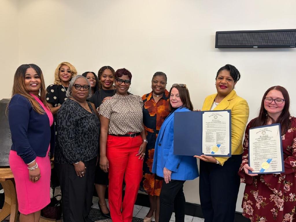 A group of women, two of whom are holding certificates