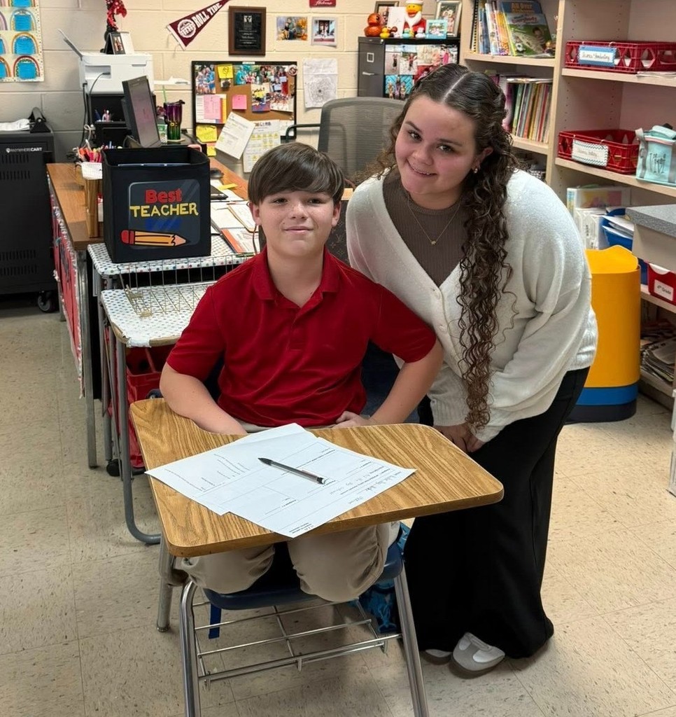 A high school student and an elementary student at a desk