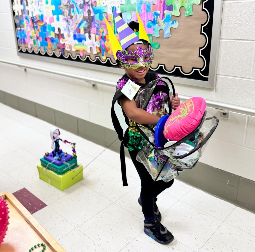 A girl in a Mardi Gras mask carries a backpack and pulls a small "float"
