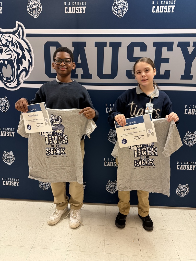 2 students holding up t-shirts and certificates