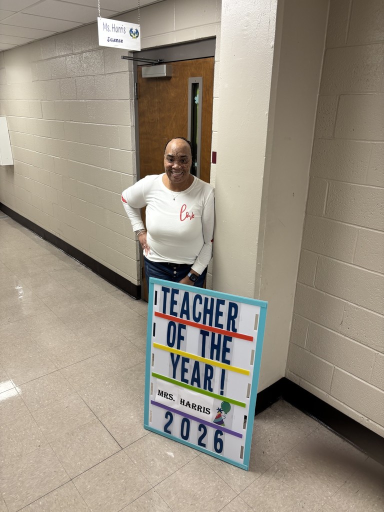The Pathway 6-12 School's Teacher of the Year 2026, Melissa Harris standing in front of her classroom and sign that says Teacher of the Year Mrs. Harris 2026.