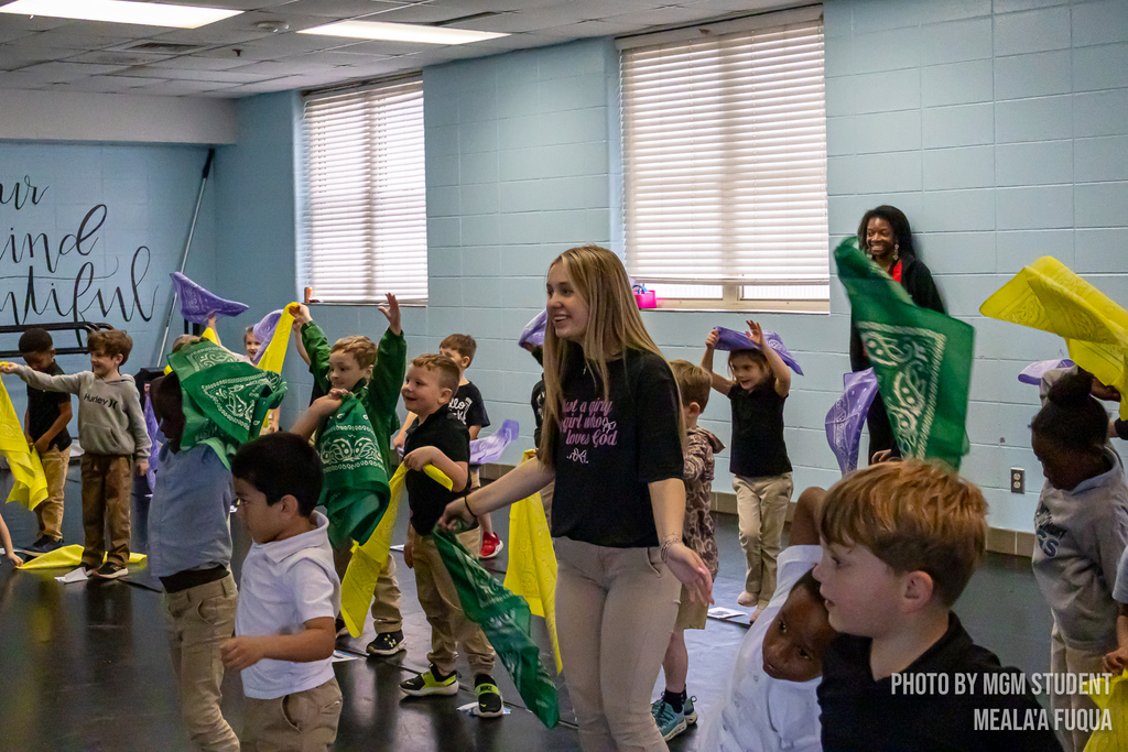 Pre-K students learning the steps and traditions to create their very own second line outside.