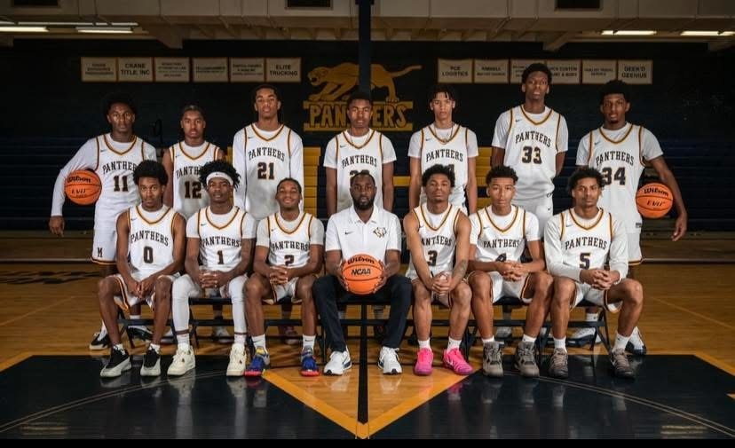 A group of basketball players in white uniforms with their coach