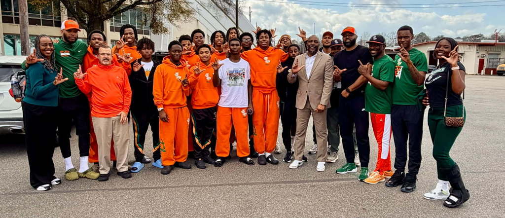 A group of basketball players in orange sweatsuits