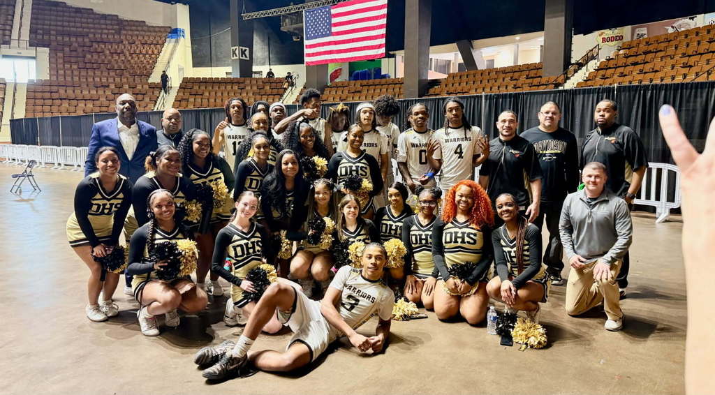 A group of basketball players and cheerleaders in black and gold uniforms