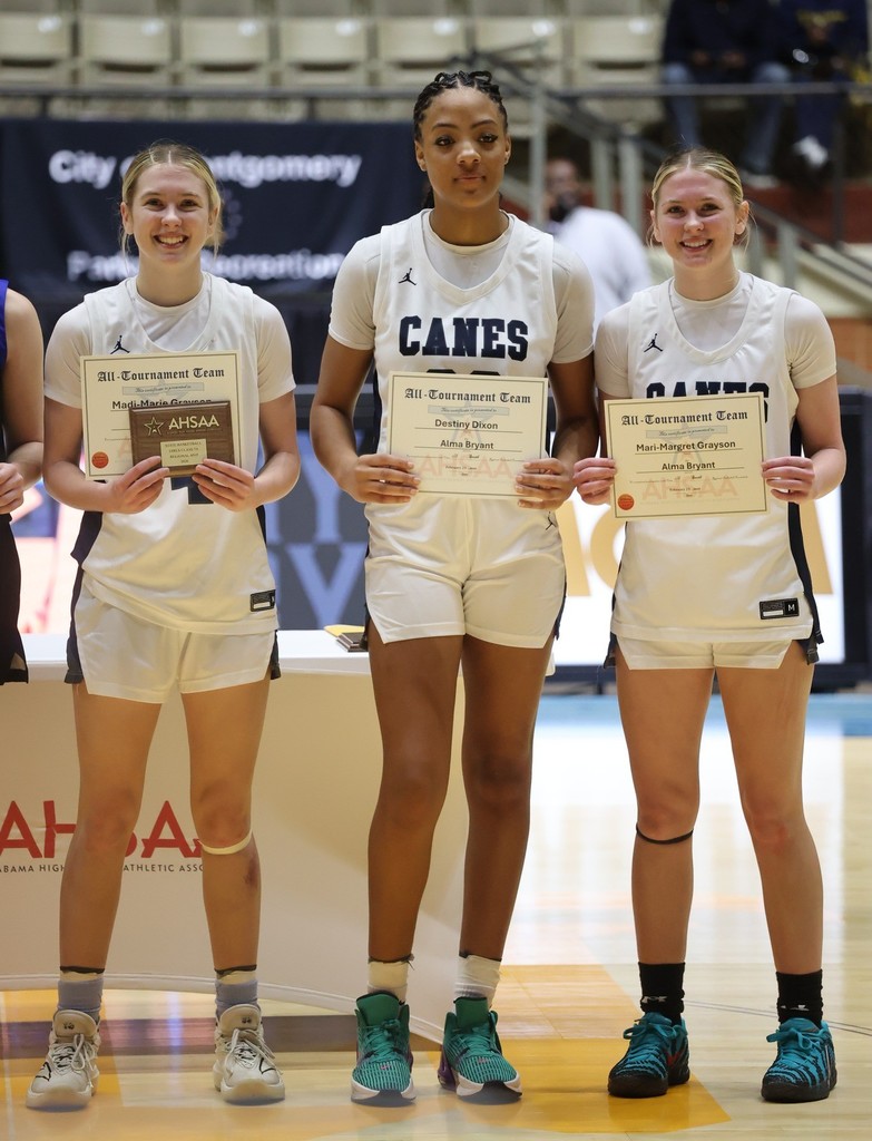Three high school basketball players holding certificates