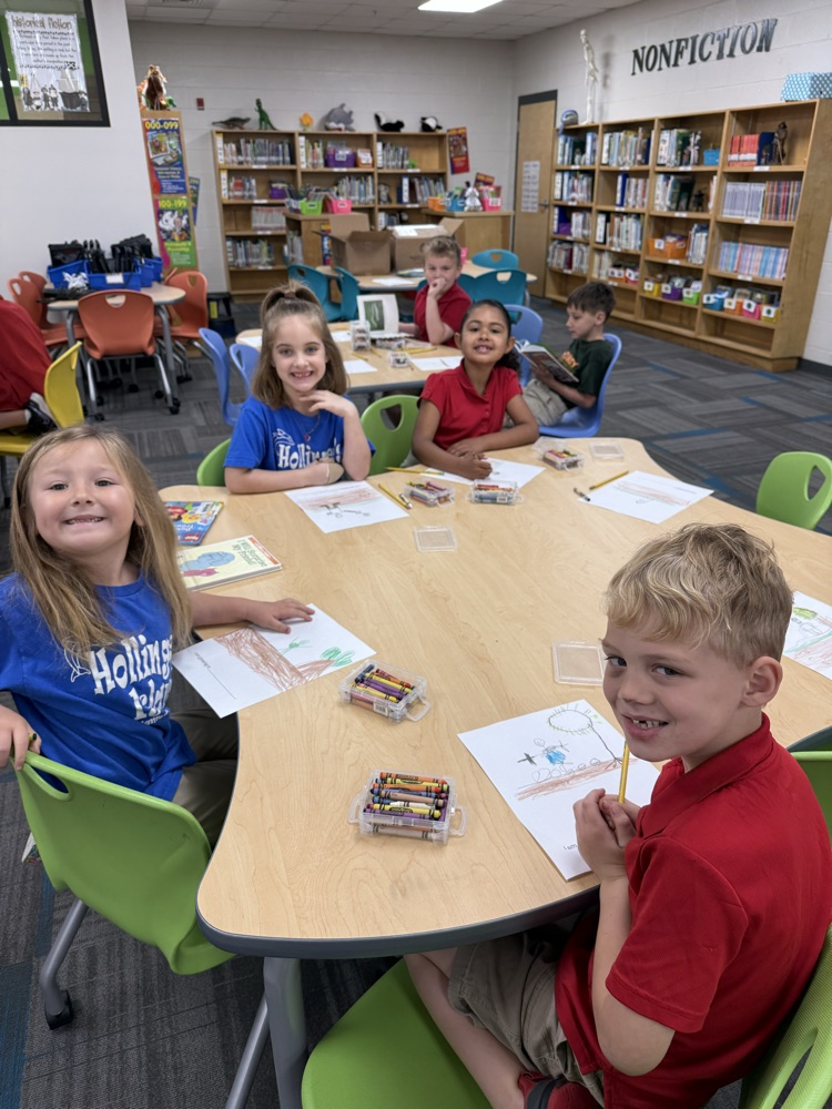 first graders coloring at a table in the library