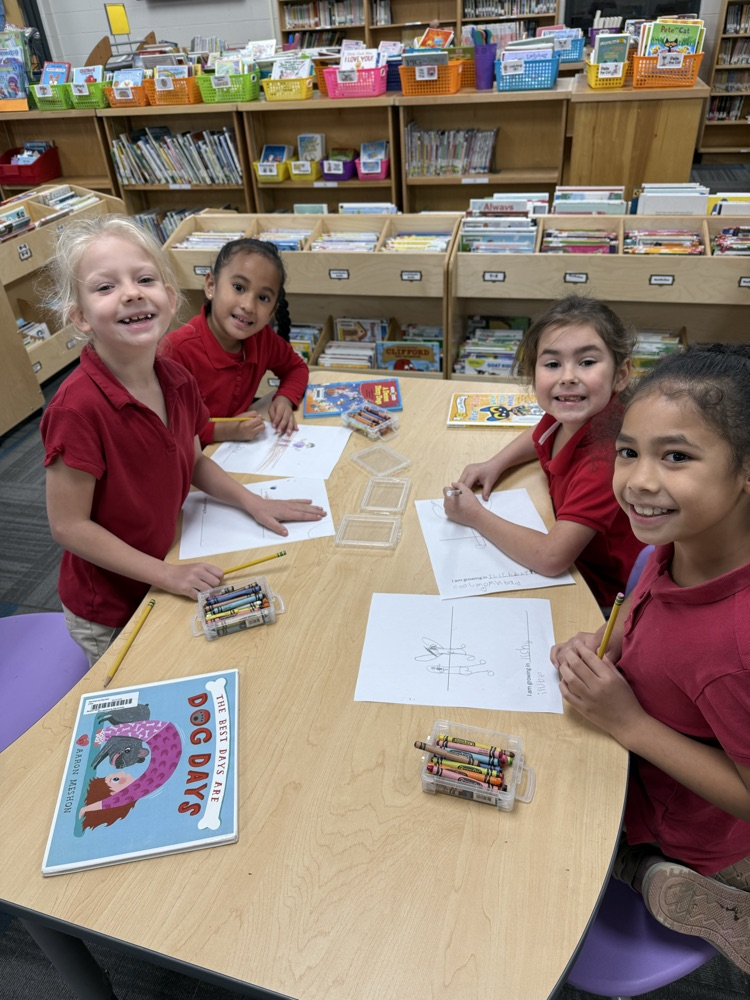 first graders coloring at a table in the library
