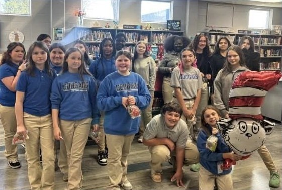 Students in a library, with a Cat in the Hat balloon