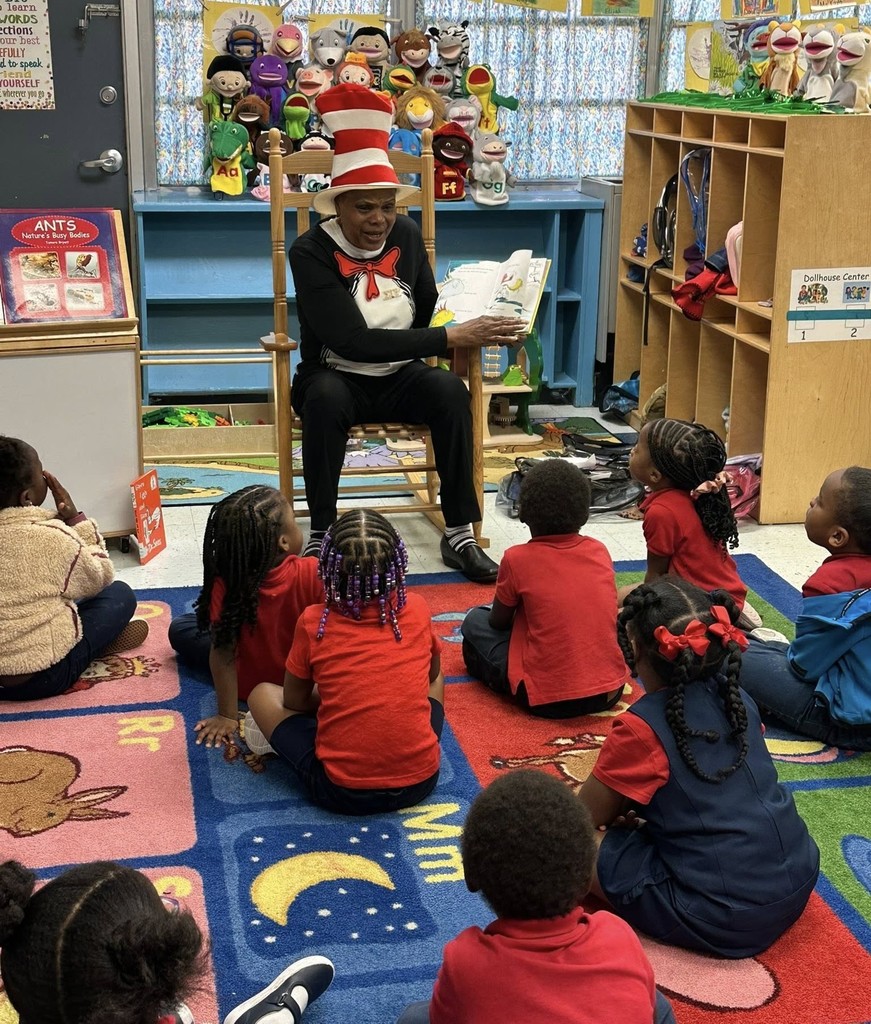 A woman in a Cat in the Hat costume reading to students