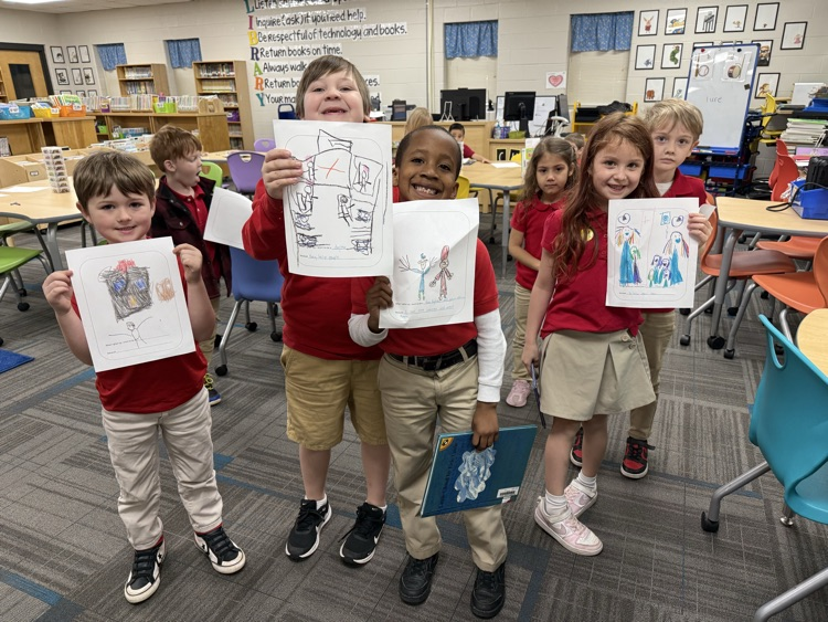 kindergarten students holding up drawings if what they want to be when they grow up