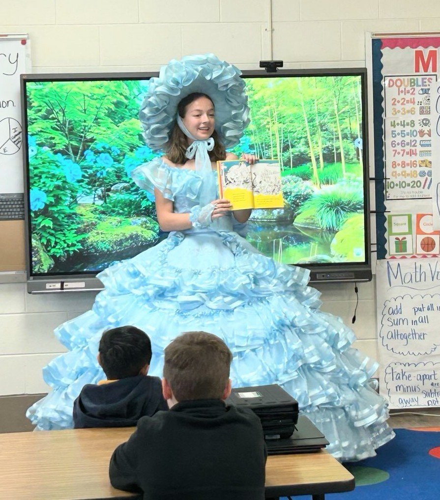 An Azalea Trail Maid reads to several children