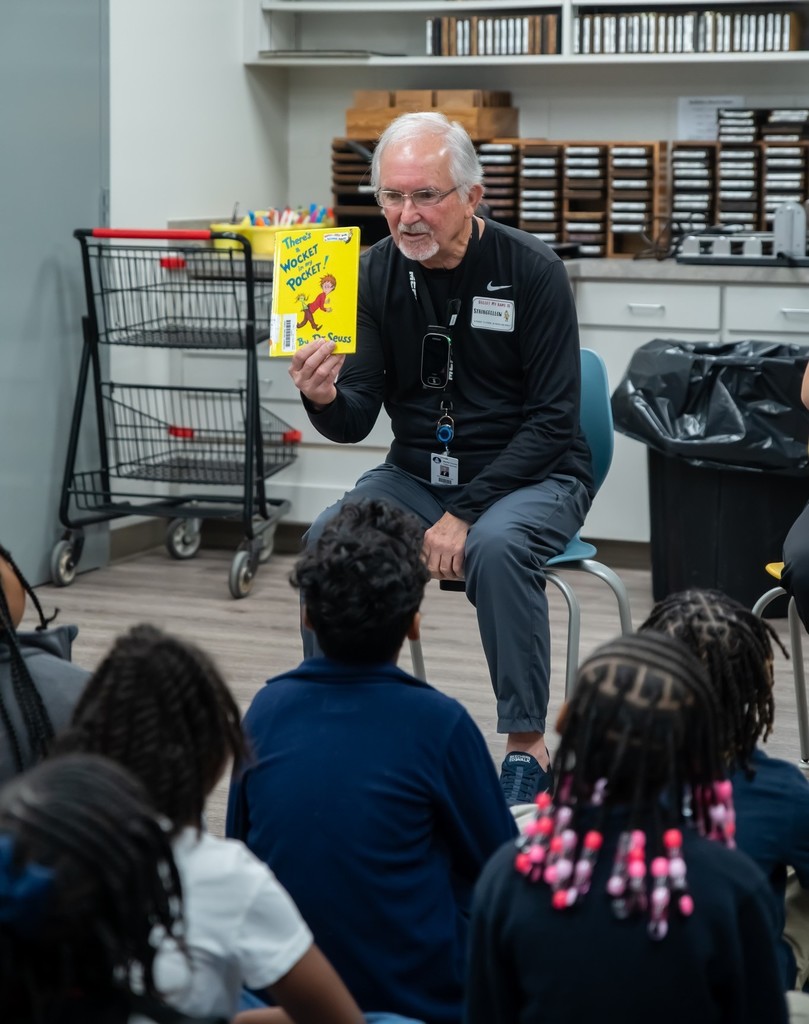 A man reading to a classroom of students