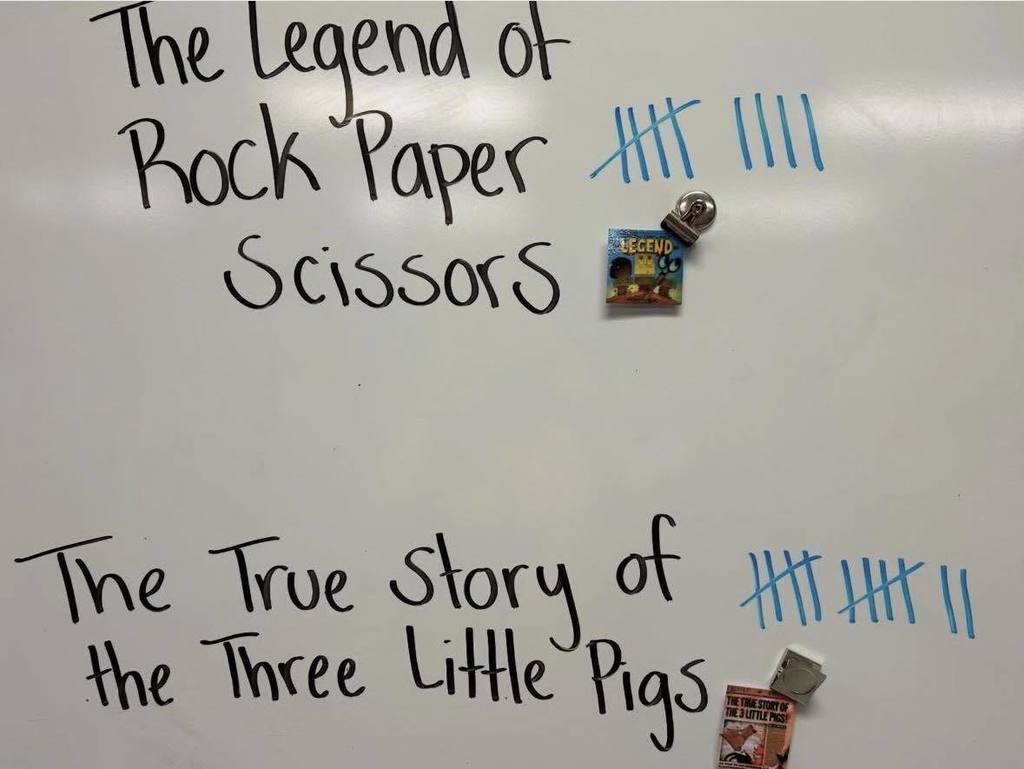 A white board with the names of two books and a tally beside each