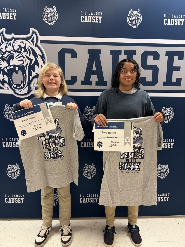 2 students holding up t-shirts and certificates