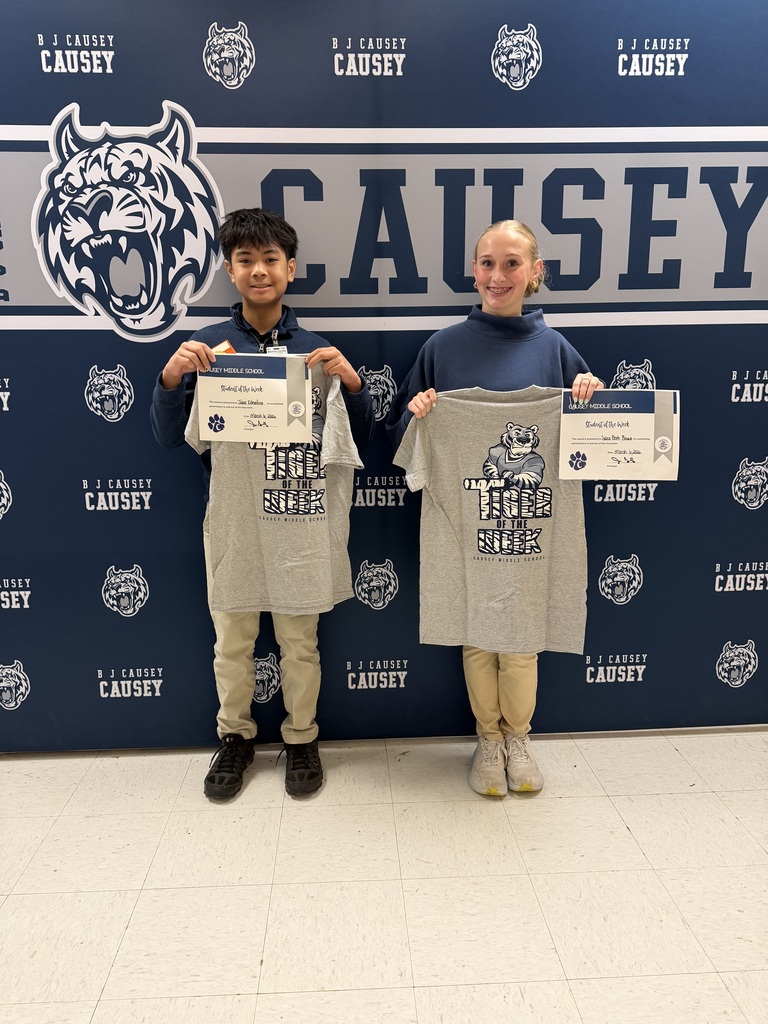 2 students holding up t-shirts and certificates