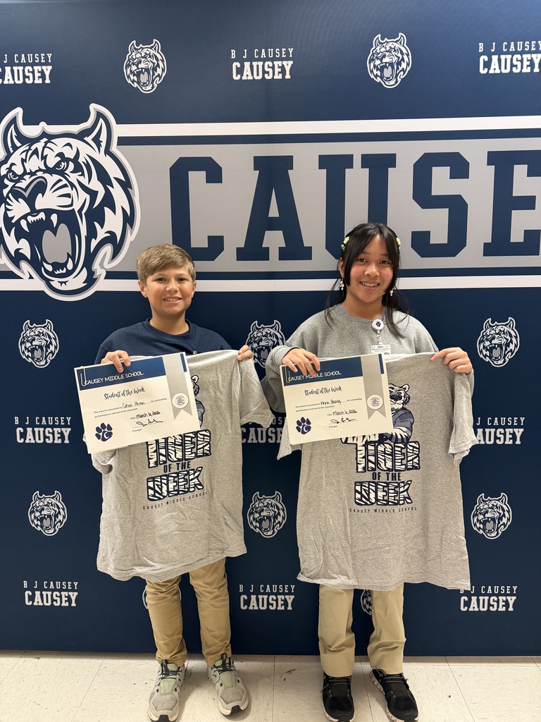 2 students holding up t-shirts and certificates