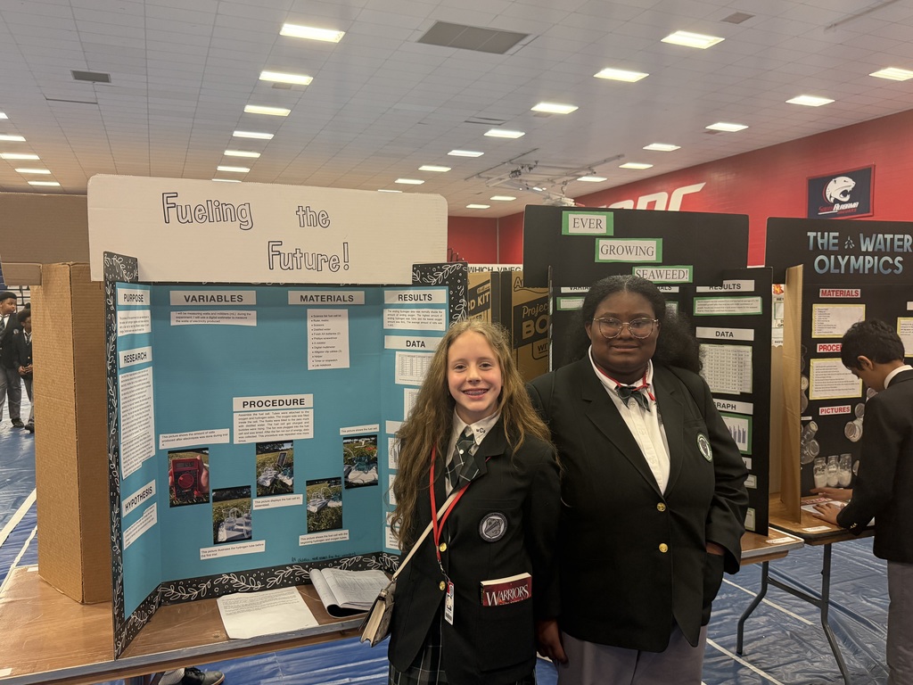 Two Clark-Shaw students stand in front of their science-project displays