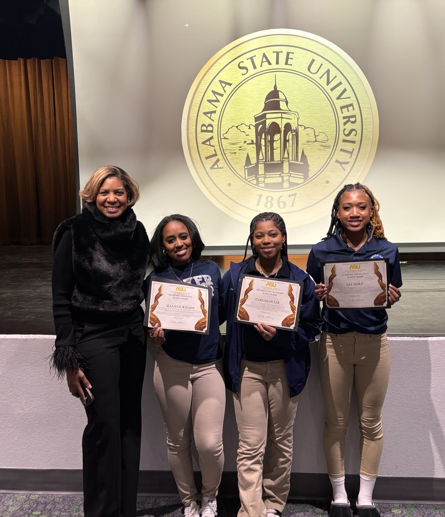 An adult stands with three Baker students holding certificates