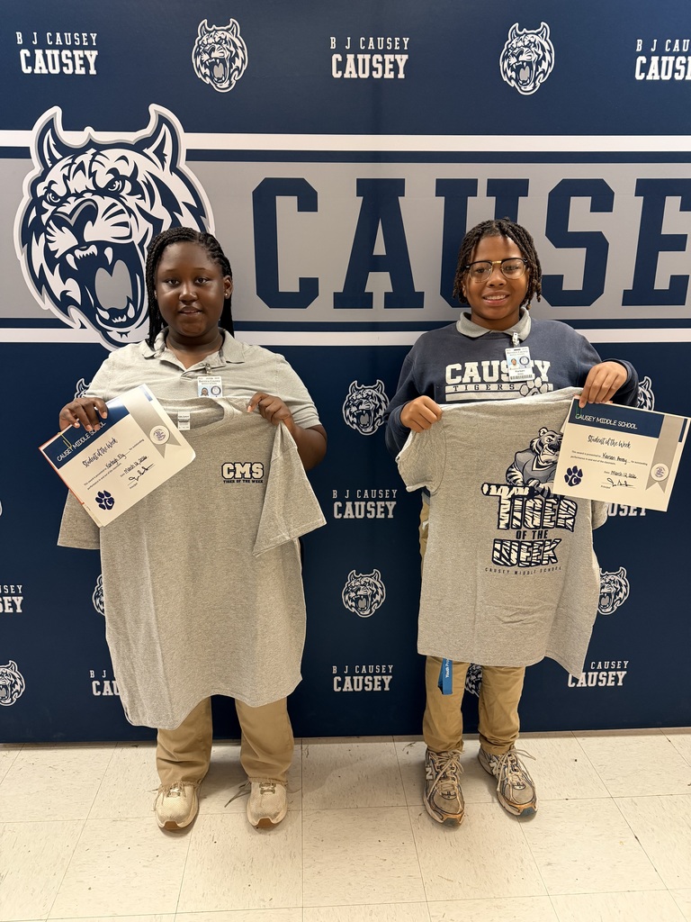 2 students holding up t-shirts and certificates