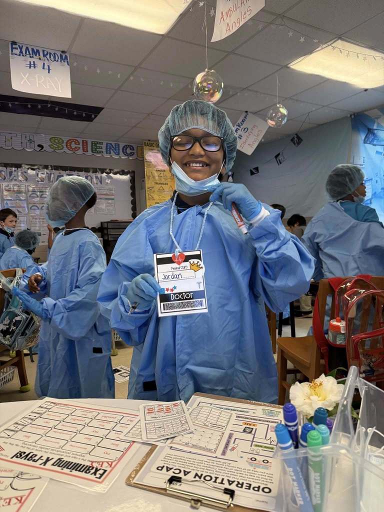 A student in hospital scrubs with a lanyard that reads "doctor"