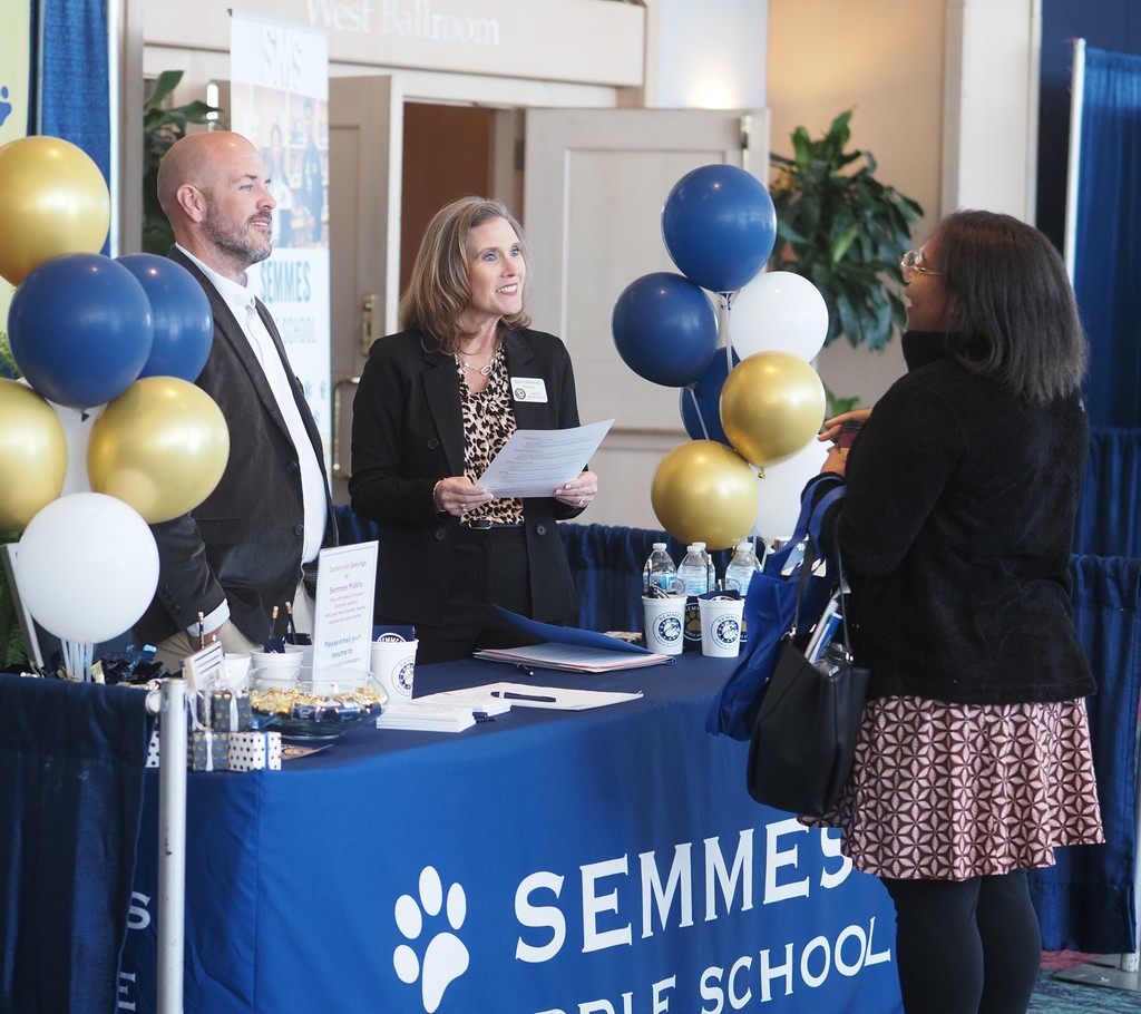 A job-seeker talking with two representatives of Semmes Middle School